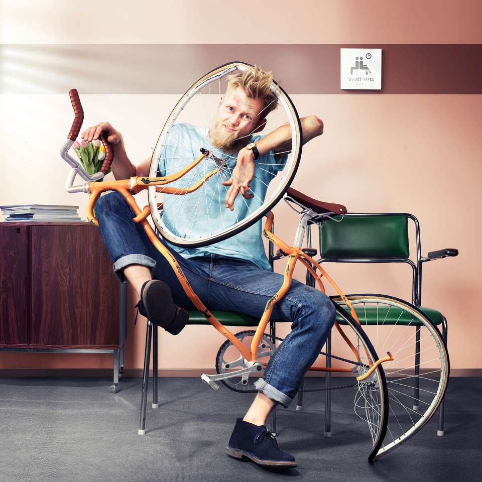 En kille har ramlat med cykeln och sitter fast i ekrarna